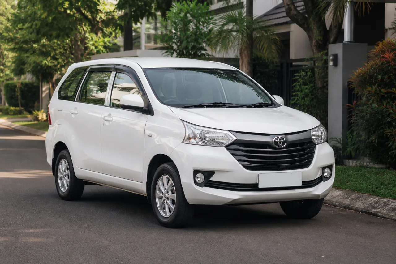 Toyota Avanza putih di jalan perumahan yang rindang